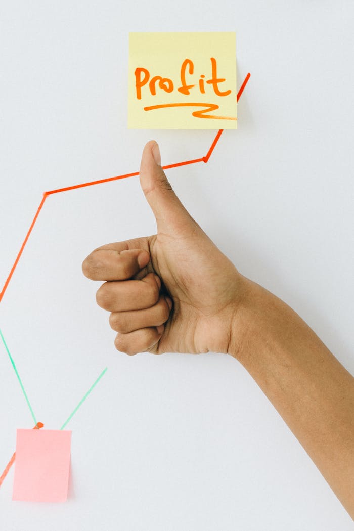 A hand giving a thumbs up in front of a profit growth chart, highlighting success.