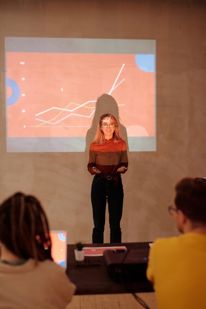 Woman presenting data with a graph projection in a business meeting.